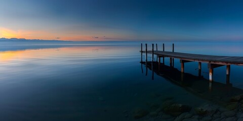 Fototapeta premium Tranquil Evening at a Lake Dock with Calm Waters and Scenic Horizon, Ideal Copy Space and Deep Depth of Field