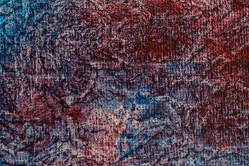 Detailed close-up of a textured abstract painting with blue and red hues, showcasing intricate patterns and vibrant colors.
