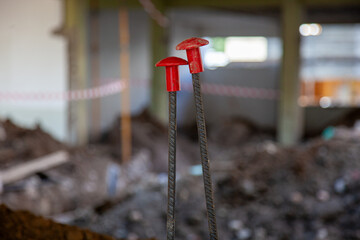 Two rebar caps securely placed on steel rods at a construction site, ensuring safety and compliance...