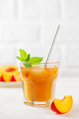 Peach and nectarine ice and mint tea on a table. Homemade cold summer drink. Vertical orientation.