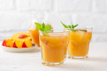 Peach and nectarine ice and mint tea on a light background. Homemade cold summer drink.