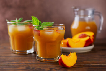 Fresh peach and nectarine ice and mint tea on a wooden table. Homemade cold summer drink. Juice, cocktail, lemonade made from peach.