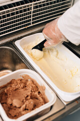 The seller puts a ball of ice-creamby scoop