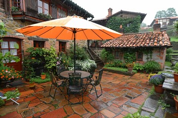 Obraz premium Cozy courtyard with orange umbrella and green plants, creating a charming and inviting outdoor retreat.