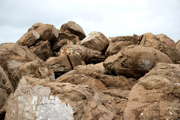 Rugged Boulders Piled Against a Moody Sky, Capture the essence of raw nature with this stock image featuring a heap of weathered boulders.