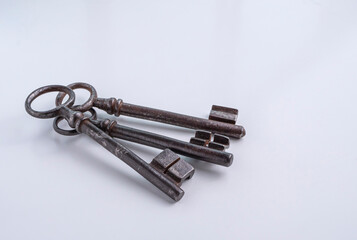 Vintage, rusty, iron keys on a white surface.

