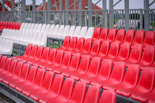 Białe i czerwone krzesełka sportowe