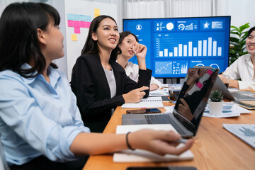 Diverse group of business analyst team analyzing financial data report. Finance data analysis chart and graph dashboard show on TV screen in meeting room for strategic marketing planning. Habiliment