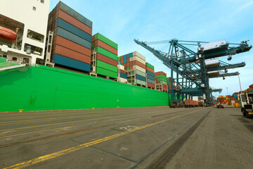 Obraz premium Cargo ship being loaded with containers at the port of San Antonio in Chile.