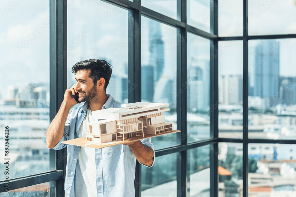 Poster handsome skilled architect engineer holds architectural model while inspect house model. professiona