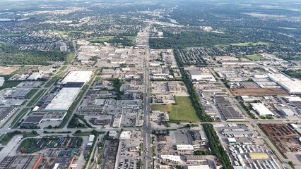 Aerial view of an urban industrial area with various buildings and greenery in the background
