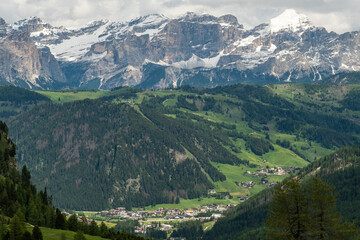 Fototapeta premium Colfosco and Majestic Mountains: A Stunning View from the Sella Group Hiking Trail