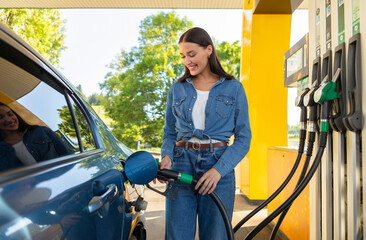Smiling lady refilling auto at modern self-service petrol station, convenient car care, automobile fueling offer concept
