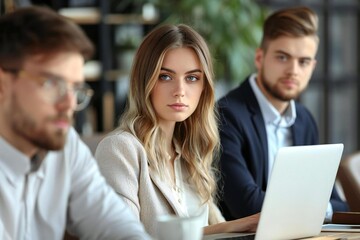 Obraz premium Beautiful businesswoman being watched by handsome businessmen while working on laptop in office setting.