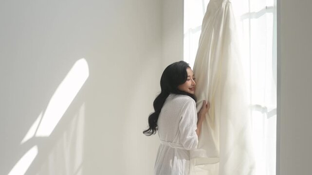 Bride in White bathrope touching and admiring elegant wedding dress preparing for wedding day, Love and marriage concept