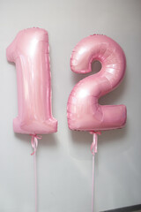 pink balloons number 12 on white background