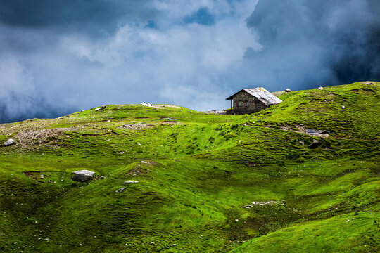 Serenity serene lonely scenery background concept - house in mountains on alpine meadow in clouds. Rohtang La pass, Himachal Pradesh, India