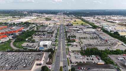 Fototapeta premium Aerial view of an industrial area with a main road running through the center on a sunny day