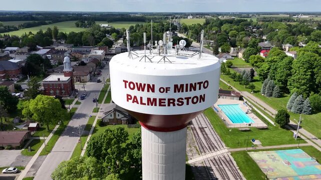 the Water Tower of Minto Palmerston town with houses, road and green fields in Ontario, Canada