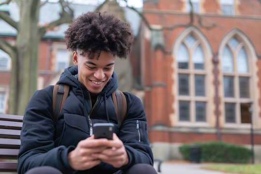 Teenage boy using a smartphone while sitting on a bench, representing connectivity and social media. Concept for modern communication, suitable for Safer Internet Day