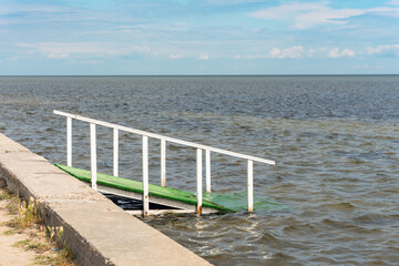 Wooden gangway into the sea at the beach on a sunny day