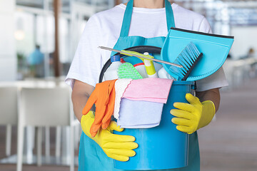 Cleaning woman with a bucket of cleaning products.