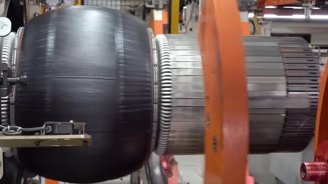 Robotic tire manufacturing machine stamping rubber tape in modern manufacture. Technological automotive industrial mechanism working at factory producing car tyre