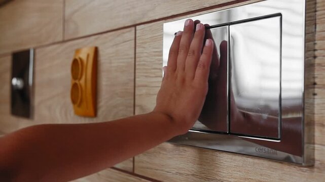 the child presses a button on the wall, flushes the toilet