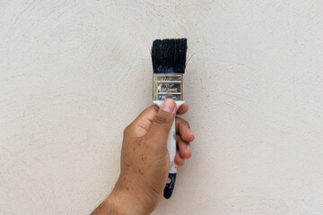 Brocha en mano para pintar la pared de una casa