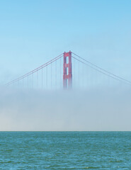 Golden Gate Bridge in a foggy weather. Only one tower is visible because of the fog. The Golden Gate Bridge is a suspension bridge spanning the Golden Gate, connecting San Francisco Bay and the Pacifi