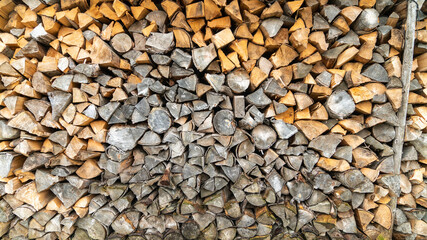 Cut wood logs stored in a storage yard. This woodpile are chopped and saved to burn in a stove...