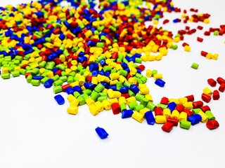 Various colored masterbatch granules on a white background, polymers that carry color pigments in...
