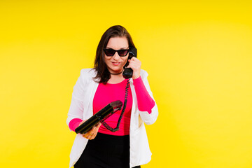 Photo portrait of plump female holding phone isolated on yellow background