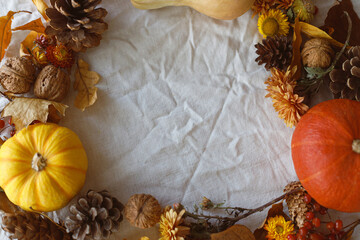 Thanksgiving background. Pumpkins, fall leaves and flowers, berries and pine cones in frame on linen cloth, space for text. Autumn harvest still life. Happy Thanksgiving. Fall banner