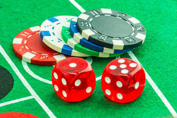 Dice with a winning combination in poker on a black table and chips in the background. Poker Chips on a gaming table
