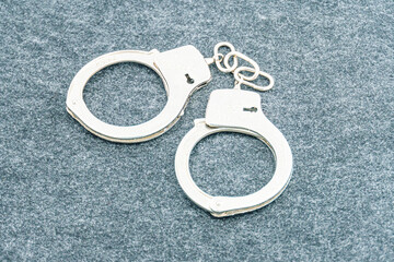 Handcuffs on an empty background, photography. Police handcuffs on dark background with copy space....