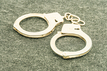 Handcuffs on an empty background, photography. Police handcuffs on dark background with copy space....