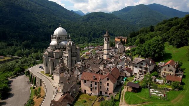 Sanctuary of Re Piedmont Italy 4k drone view flying between dome and bell tower. Madonna del Sangue basilica scenic hilltop village in Vigezzo valley aerial reveal b-roll Hidden gems