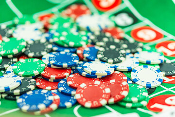 Poker Table With Poker Chips Turns In Casino. Many Poker Chips Spins on the Table in Darkness. with a winning combination in poker on a black table and chips in the background. Poker Chips on a gaming