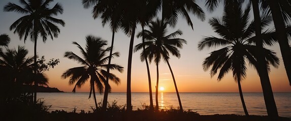 A nostalgic photograph of a tropical sunset, framed by the silhouette of palm leaves. The setting sun casts a warm, orange glow across the sky and the calm ocean water, 