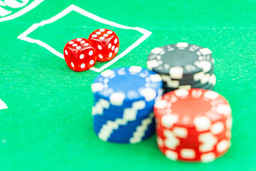Dice with a winning combination in poker on a black table and chips in the background. Poker Chips on a gaming table