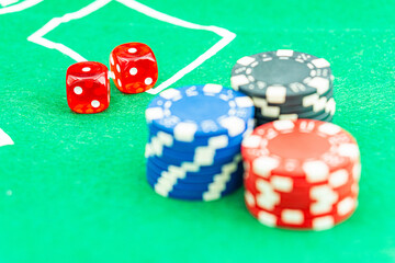 Dice with a winning combination in poker on a black table and chips in the background. Poker Chips on a gaming table