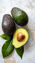 Ripe avocados with leaves, white background. Healthy eating and nutrition concept