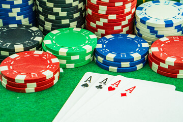 Background with cards chips and dices for playing casino gambling on green felt mat and green isolated background Front view.