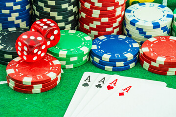 Background with cards chips and dices for playing casino gambling on green felt mat and green isolated background Front view.