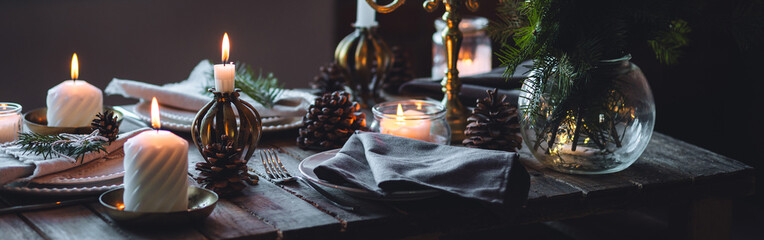 Banner. Elegant decor for Christmas family dinner. Center piece with burning candles, vintage chandelier. Zero waste eco-friendly home decoration, fir tree branches. Cozy atmosphere, wooden furniture