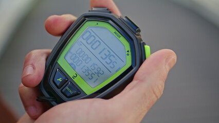 Hand pressing sport timer on race competition. Closeup man holding stopwatch