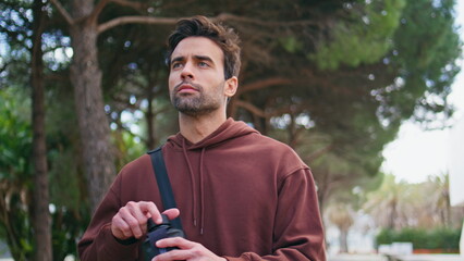 Athletic guy drinking water on street closeup. Handsome man runner hydrating