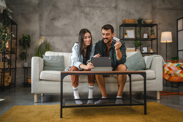 Obraz premium Adult caucasian couple buy online on digital tablet with credit card