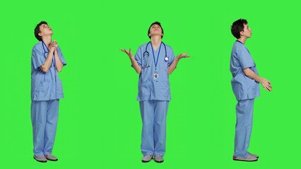 Hospital nurse worshipping God by prayer against greenscreen backdrop, praying to jesus christ and having hope in christianity and spirituality. Medical assistant doing meditation. Camera A.